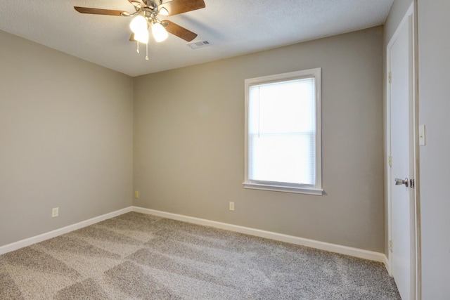 carpeted empty room featuring ceiling fan and a textured ceiling