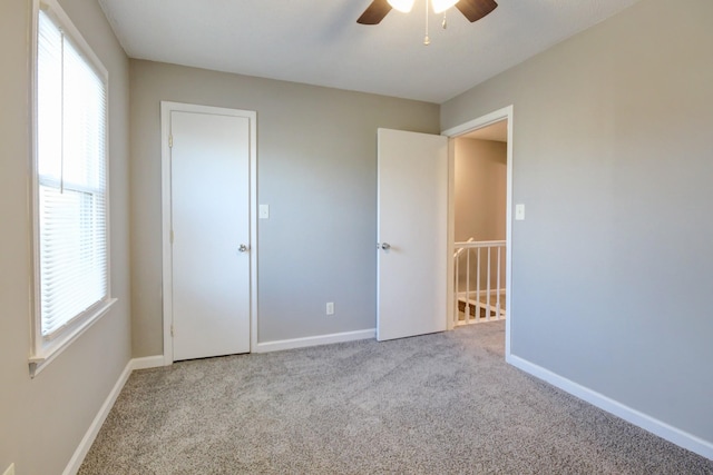 unfurnished bedroom featuring ceiling fan and light colored carpet