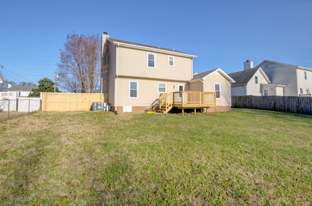 rear view of property with central air condition unit, a wooden deck, and a yard