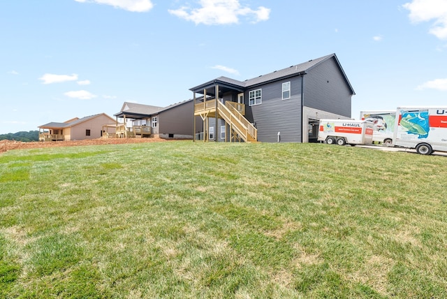 rear view of house with a yard and a deck