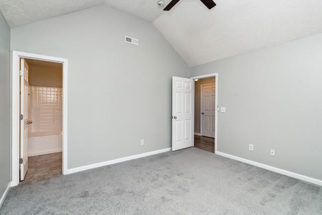 unfurnished bedroom featuring vaulted ceiling, connected bathroom, ceiling fan, and a textured ceiling