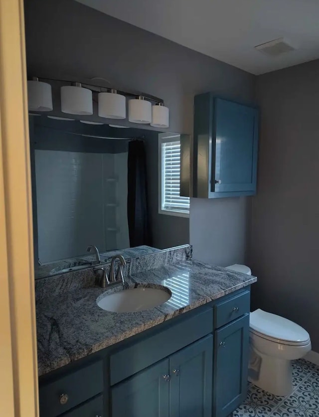 bathroom featuring tile patterned floors, vanity, and toilet