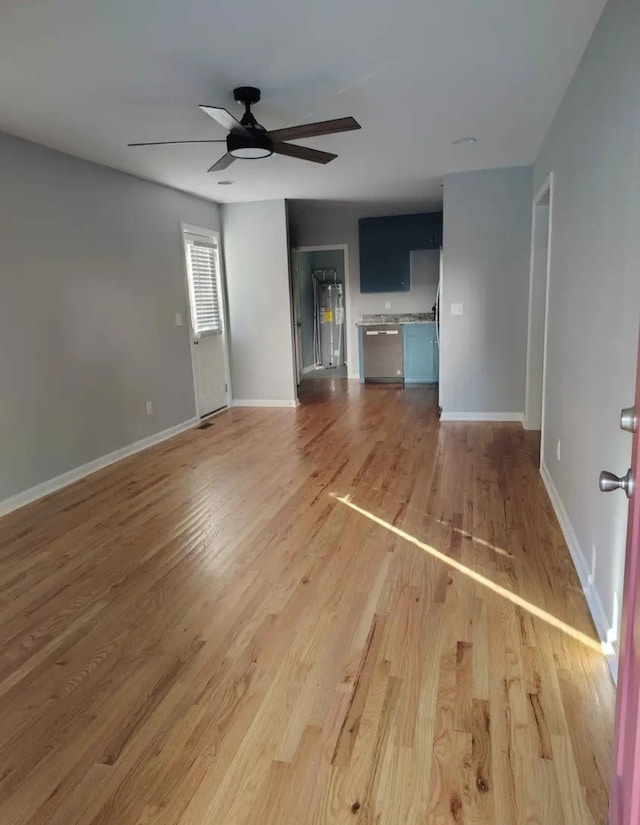 unfurnished living room with ceiling fan, wood-type flooring, and water heater