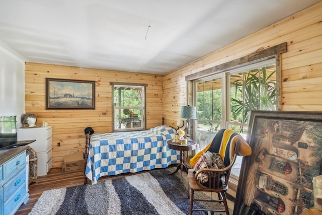 bedroom featuring dark hardwood / wood-style flooring and wood walls