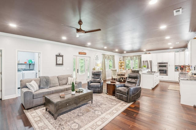 living room with dark wood-type flooring, ceiling fan, ornamental molding, and independent washer and dryer