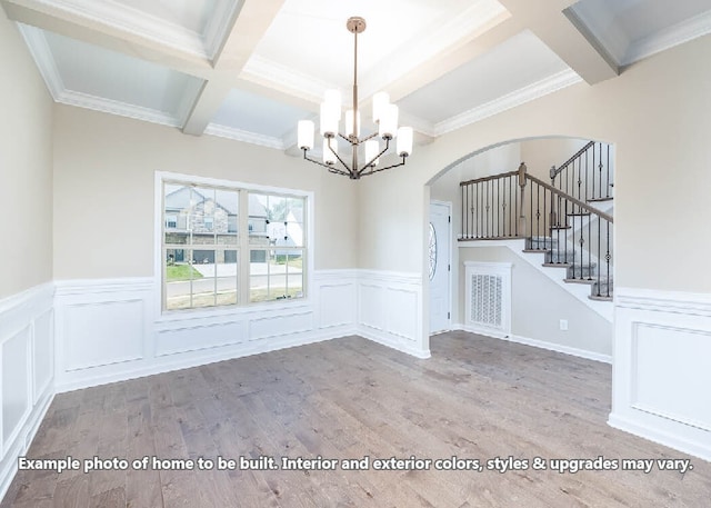 unfurnished dining area with coffered ceiling, beamed ceiling, stairway, and wood finished floors