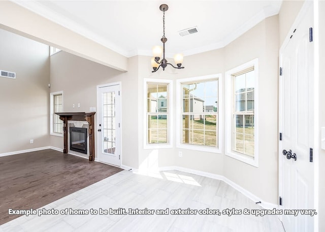 interior space featuring a glass covered fireplace, visible vents, plenty of natural light, and baseboards