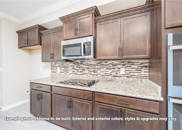 kitchen with crown molding, decorative backsplash, appliances with stainless steel finishes, light stone countertops, and baseboards