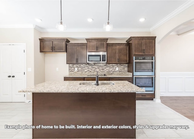 kitchen with stainless steel appliances, tasteful backsplash, dark brown cabinets, and light stone countertops