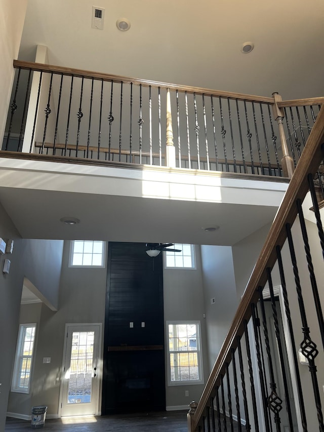 interior space featuring stairway, a healthy amount of sunlight, and a towering ceiling