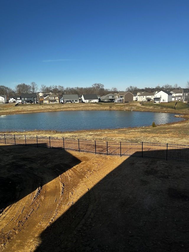 view of yard with a water view, a residential view, and fence