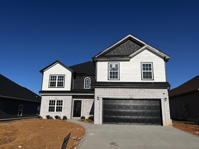 view of front of home featuring a garage, concrete driveway, and brick siding