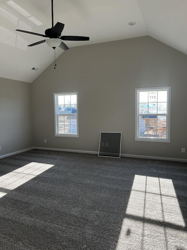 empty room with dark colored carpet, high vaulted ceiling, visible vents, and baseboards