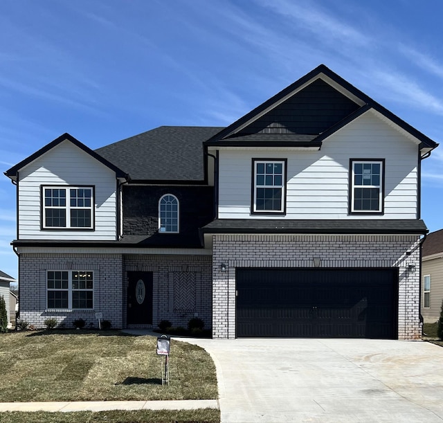 traditional-style house featuring brick siding, roof with shingles, an attached garage, a front yard, and driveway