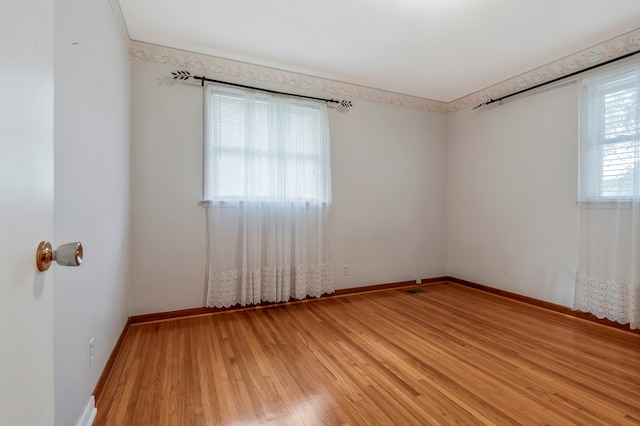 unfurnished room with hardwood / wood-style flooring and a wealth of natural light