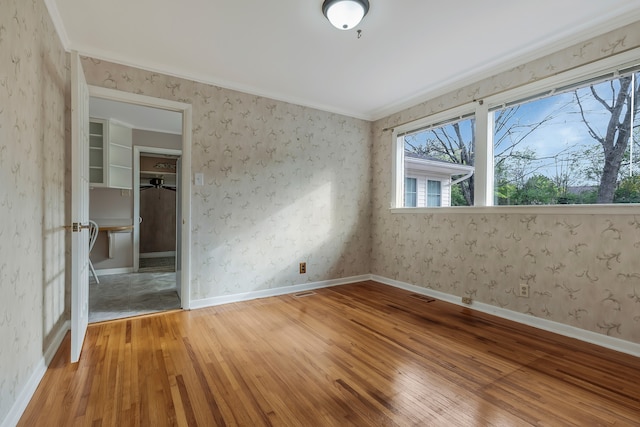 spare room featuring hardwood / wood-style floors and crown molding