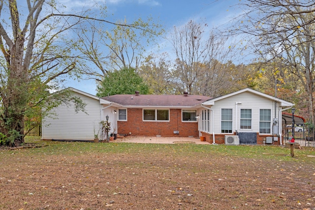 back of property with ac unit, a patio, and a carport