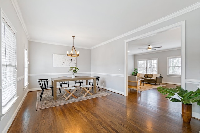 dining room with dark hardwood / wood-style floors, ornamental molding, and ceiling fan with notable chandelier