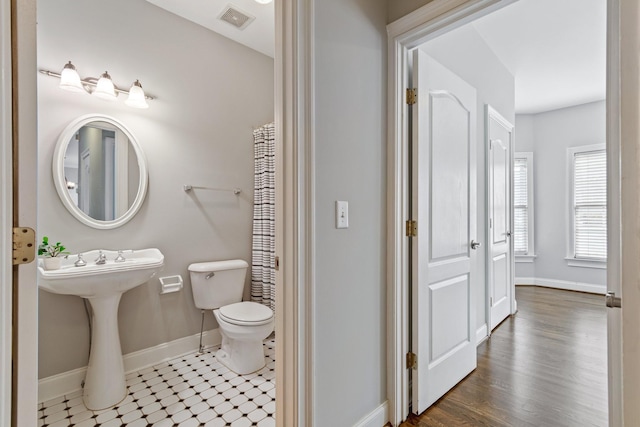 bathroom featuring wood-type flooring and toilet