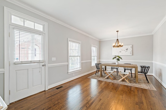 dining room featuring hardwood / wood-style floors, a healthy amount of sunlight, and ornamental molding