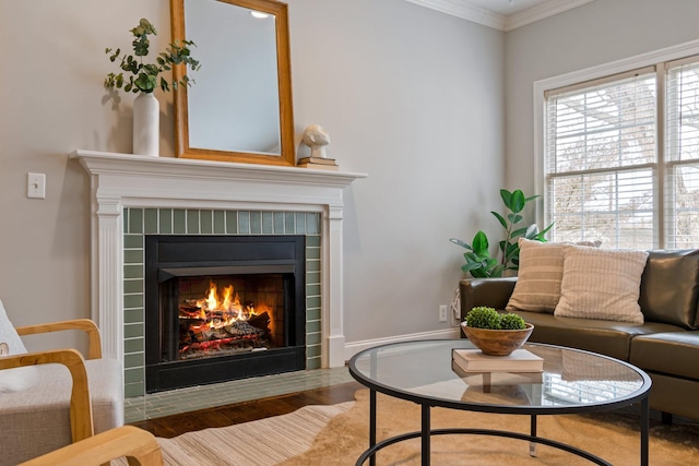 sitting room featuring a fireplace, wood-type flooring, and ornamental molding