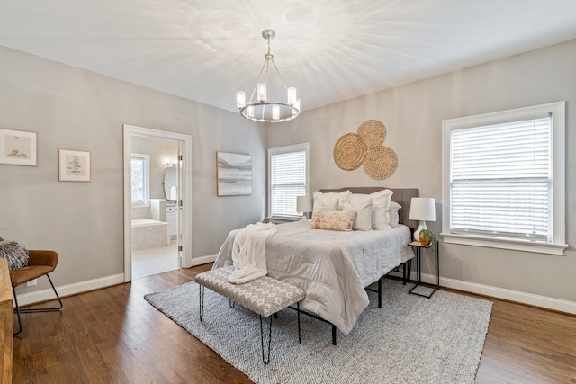 bedroom featuring hardwood / wood-style flooring, an inviting chandelier, and ensuite bath