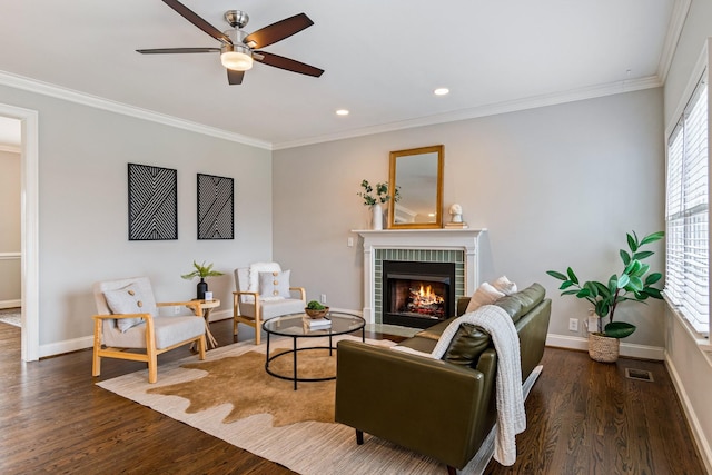 living room featuring a brick fireplace, ceiling fan, dark hardwood / wood-style floors, and ornamental molding