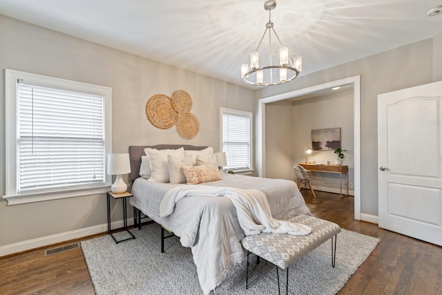 bedroom featuring dark hardwood / wood-style floors and an inviting chandelier