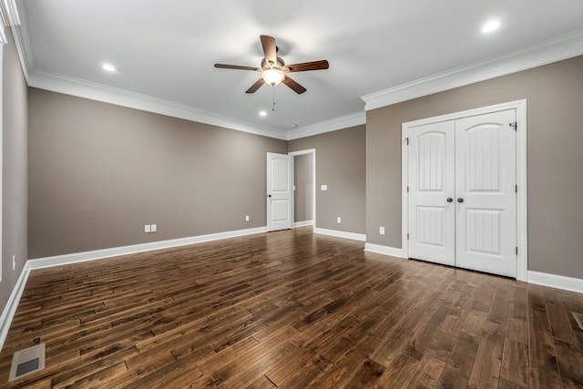 unfurnished bedroom featuring a closet, dark hardwood / wood-style floors, ceiling fan, and crown molding