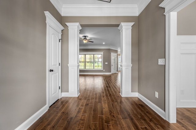 hall with dark hardwood / wood-style flooring, ornate columns, and ornamental molding