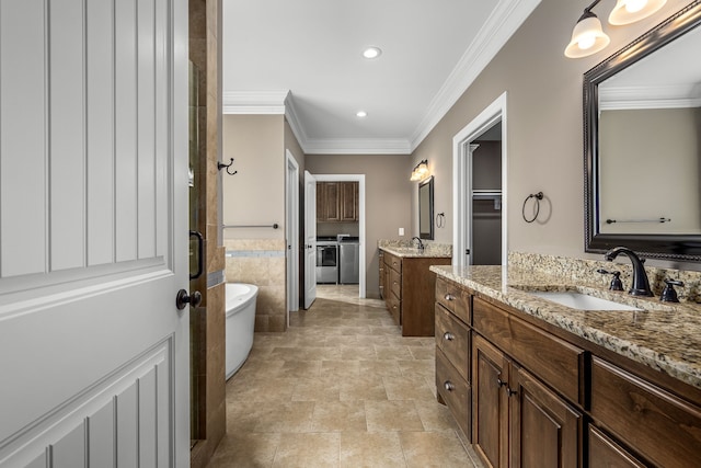 bathroom featuring vanity, separate washer and dryer, separate shower and tub, and crown molding