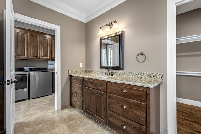 bathroom with vanity, washer and clothes dryer, and ornamental molding