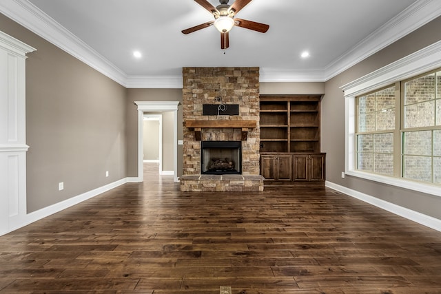 unfurnished living room with ornate columns, ceiling fan, dark wood-type flooring, crown molding, and a fireplace