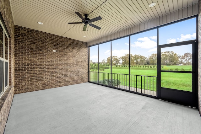 unfurnished sunroom featuring ceiling fan