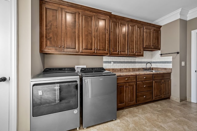 laundry room featuring cabinets, ornamental molding, sink, washer and dryer, and light tile patterned floors