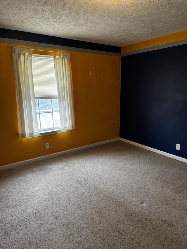 carpeted empty room featuring a textured ceiling