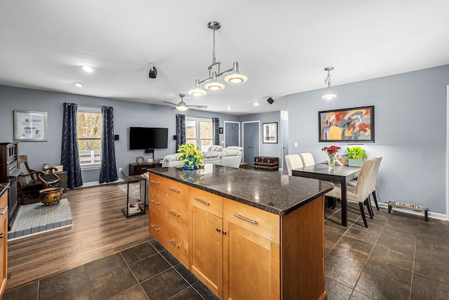 kitchen featuring plenty of natural light, pendant lighting, and dark hardwood / wood-style floors