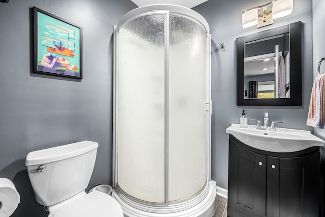 bathroom with vanity, toilet, and a shower with door