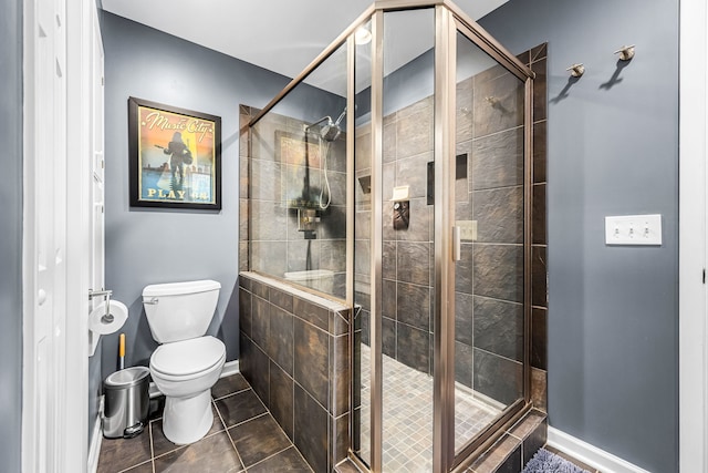 bathroom featuring tile patterned floors, an enclosed shower, and toilet