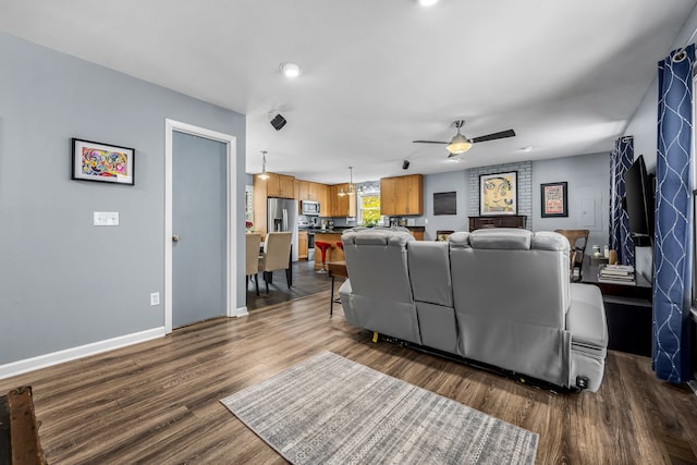 living room featuring ceiling fan and dark wood-type flooring