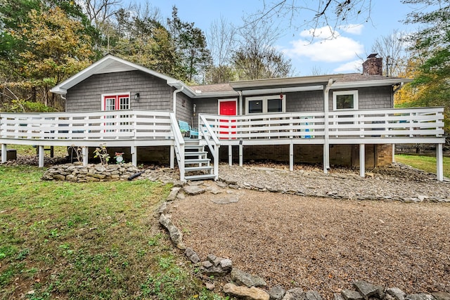 back of house featuring a lawn and a wooden deck