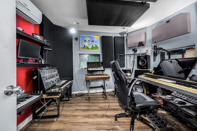 office space featuring a wall mounted air conditioner and wood-type flooring