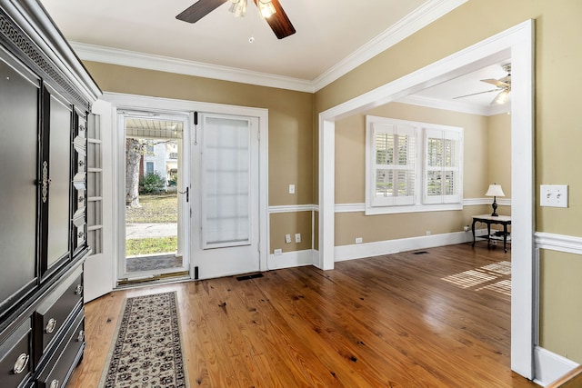 foyer with hardwood / wood-style flooring, ceiling fan, and crown molding