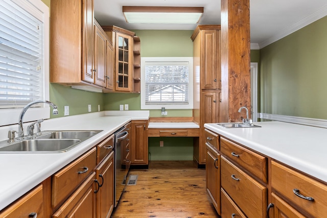 kitchen featuring dishwasher, light hardwood / wood-style flooring, ornamental molding, and sink