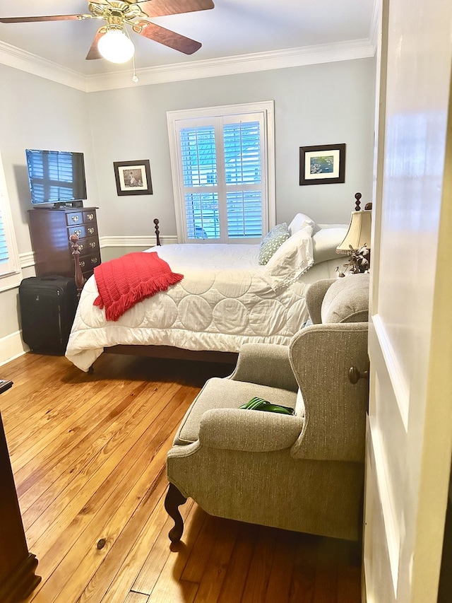 bedroom featuring ceiling fan, crown molding, and wood-type flooring