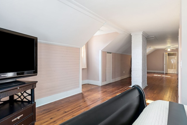 additional living space featuring ceiling fan, lofted ceiling, dark wood-type flooring, and decorative columns