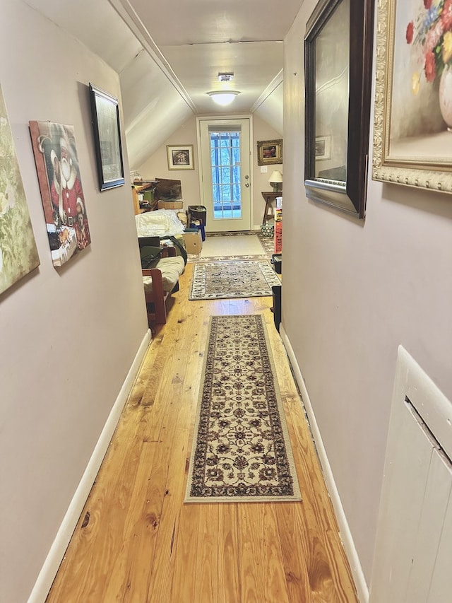 hall featuring wood-type flooring and lofted ceiling