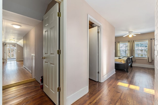 hallway with dark hardwood / wood-style flooring and lofted ceiling