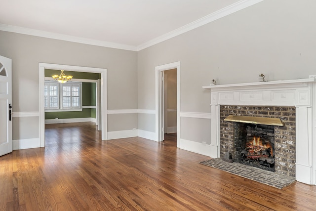 unfurnished living room featuring crown molding, a chandelier, dark hardwood / wood-style floors, and a brick fireplace