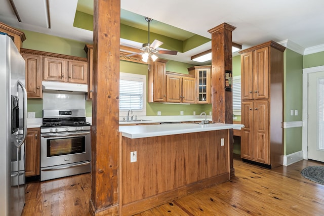 kitchen featuring decorative columns, sink, hardwood / wood-style floors, and appliances with stainless steel finishes